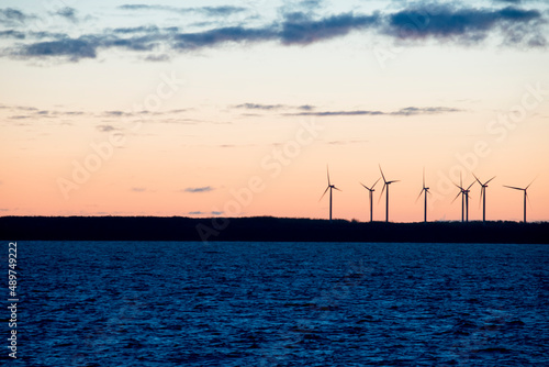 Windmill generators on a shore during sunrise.