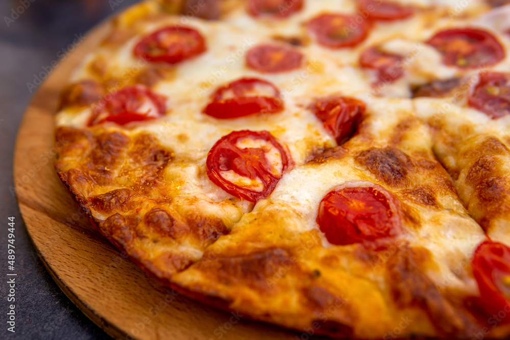 pizza margherita on a wooden plate close-up pizza margherita on a wooden plate close-up