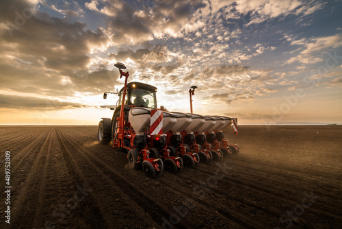 Foto Farmer with tractor seeding