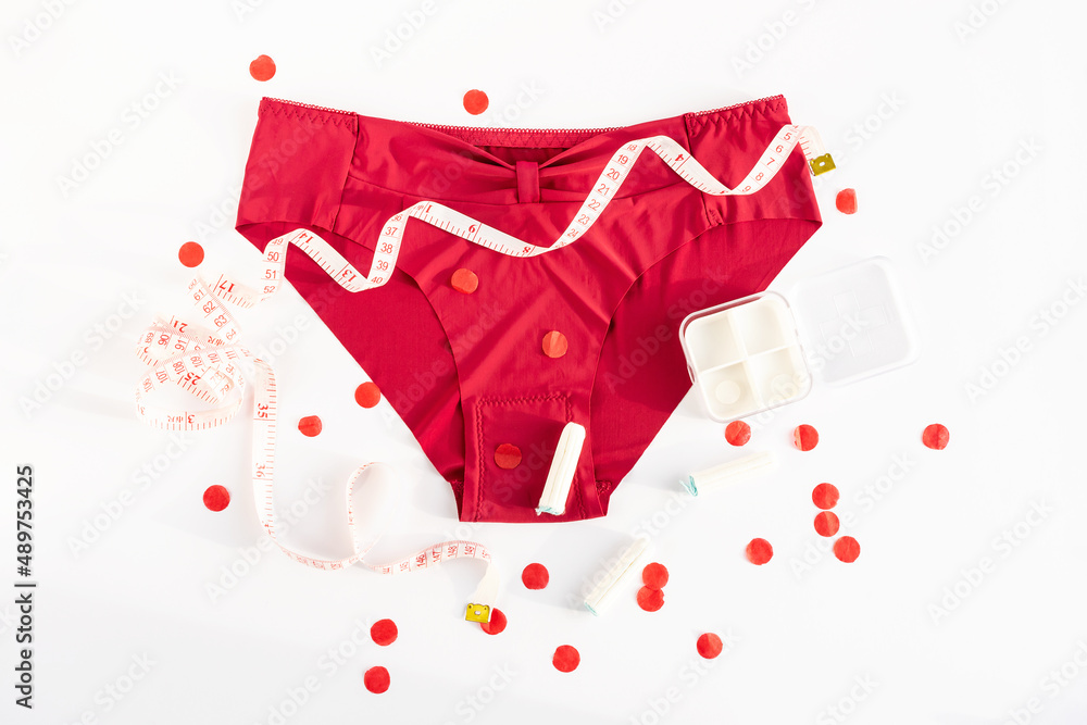 Women's underwear, tampons and metric measuring tape. Concept of