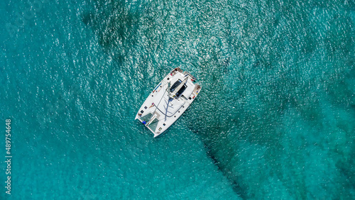 Beautiful sailing catamaran at anchor. Aerial view of a yacht in clear turquoise water in the Indian Ocean. Yachting and travel concept © Sergey Chips