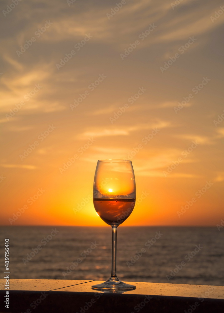 Glass of champagne against the background of the sea and sunrise