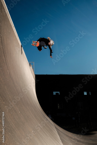 Boy doing backside air on a vert ramp and blue sky photo