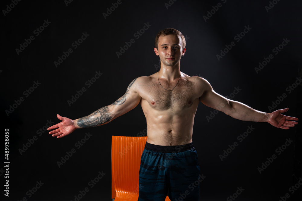 Man on black background keeps dumbbells pumped up in fitness body weight workout hold male weightlifting. Attractive skin power, guy fit