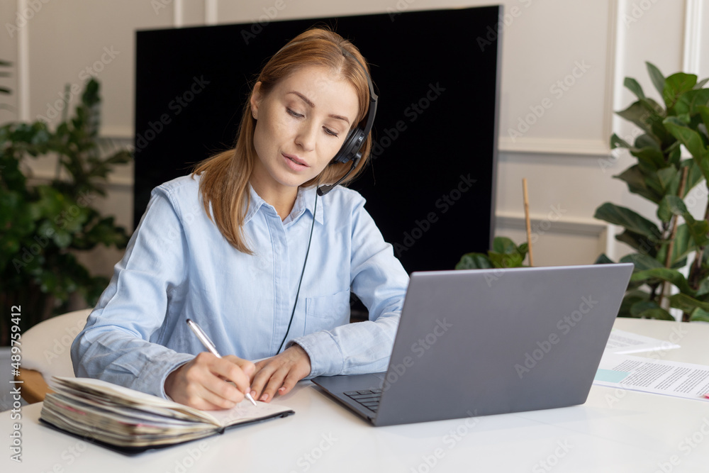 Call center operator working from home and making notes Call center operator working from home and making notes