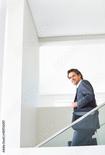 Executive walking down the stairs. Portrait of attractive mature executive walking down the stairs with bags.