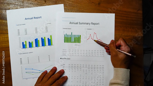 Businessman, Asian woman writing Excel graph with data spreadsheet document financial planning Prepare accounting database reports On-screen graph chart with business stationery set.