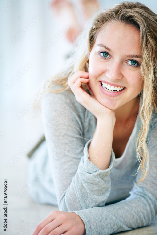 An endearing sweet nature. Closeup of a cute young blonde lying on the floor and smiling at you - Copyspace. An endearing sweet nature. Closeup of a cute young blonde lying on the floor and smiling at you - Copyspace.