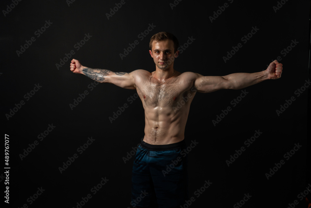 Man on black background keeps dumbbells pumped up in fitness bodybuilding biceps black, body weight workout hold male weightlifting. handsome gym fit Man on black background keeps dumbbells pumped up in fitness bodybuilding biceps black, body weight workout hold male weightlifting. handsome gym fit