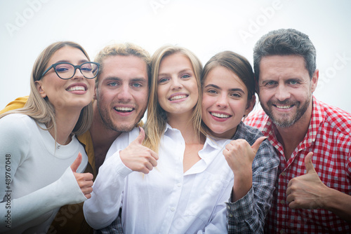 Smiling group of friends laughing with thumb up. Happy company students best friends making selfies. Group young people young friends posing together.