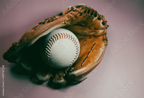 Softball in mitt with a gray background. © JMP Traveler