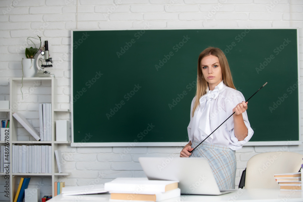 Young teacher with pointer. Portrait of cute attractive young woman student in university or high school college. Young teacher with pointer. Portrait of cute attractive young woman student in university or high school college.