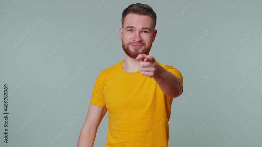 I choose you. Handsome stylish man pointing to camera and looking with playful happy expression, making choice, showing direction. Young adult guy alone. Indoors studio shot on gray wall background I choose you. Handsome stylish man pointing to camera and looking with playful happy expression, making choice, showing direction. Young adult guy alone. Indoors studio shot on gray wall background