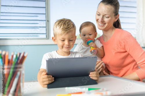 mother and child using tablet learning, doing home work, teaching at home 