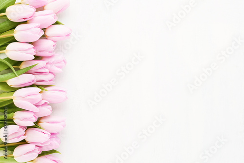 Fototapeta Naklejka Na Ścianę i Meble -  Pink tulips border on a white wooden background. Mothers Day, Valentines Day, birthday concept