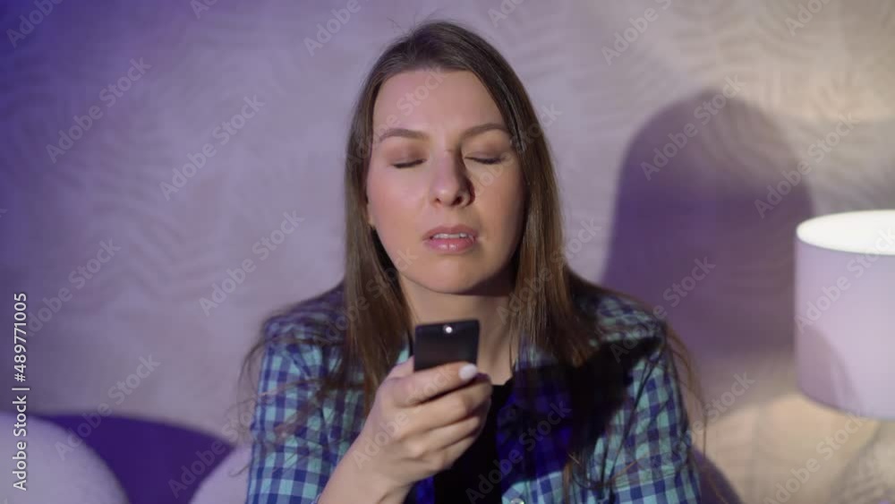 Young woman sits on an armchair and watches TV. Young woman sits on an armchair and watches TV.