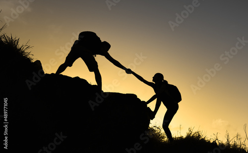 People helping each other of a mountain. Teamwork, trust, and assistance concept. 