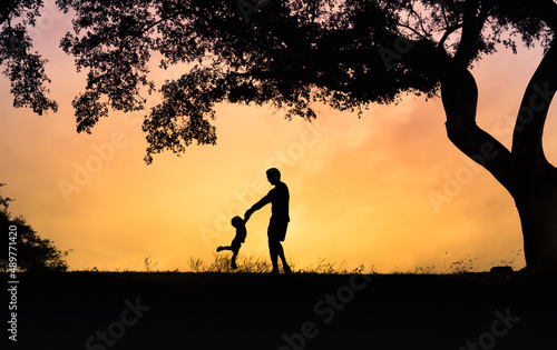 Canvas Print Happy father playing with his son holding him up in the air
