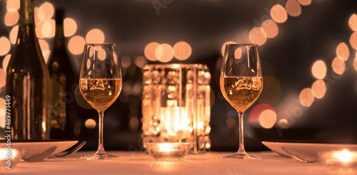 Wine glasses in a fine dinning restaurant candle light dinner romantic setting  photo