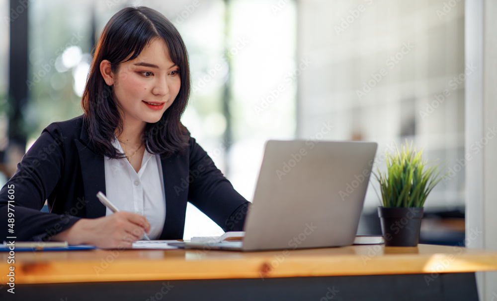 Portrait of Young Asian woman hand freelancer is working her job on computer tablet in modern office. Doing accounting analysis report real estate investment data, Financial and tax systems concept. Portrait of Young Asian woman hand freelancer is working her job on computer tablet in modern office. Doing accounting analysis report real estate investment data, Financial and tax systems concept.