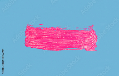 neon pink brush paint - cross isolated on blue background
