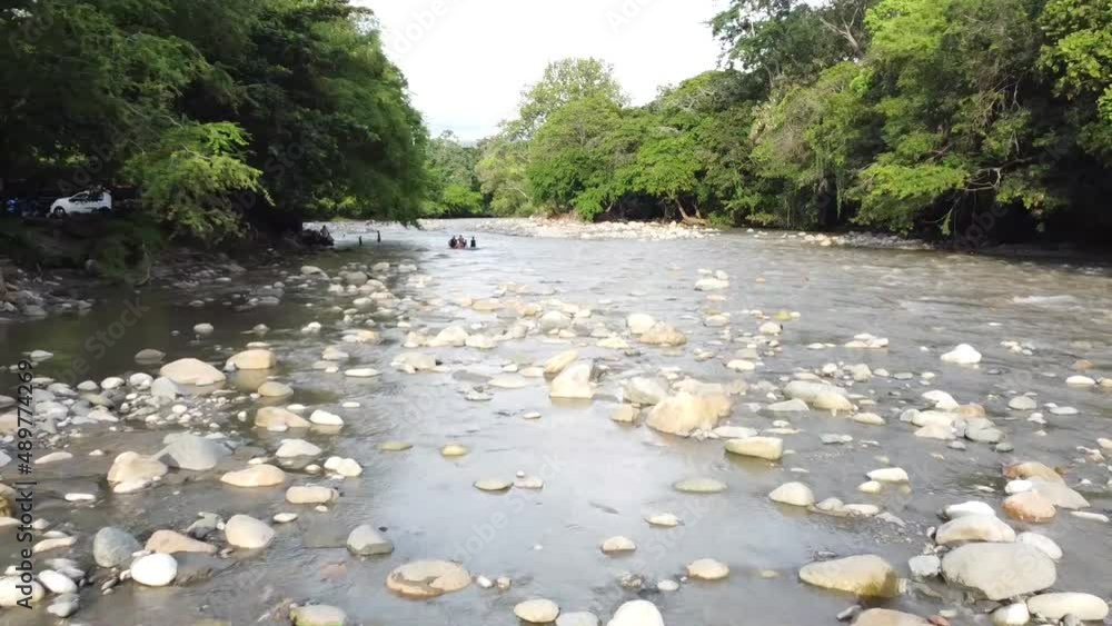 Hermoso río empedrado a lo largo del valle. Puente para cruzar