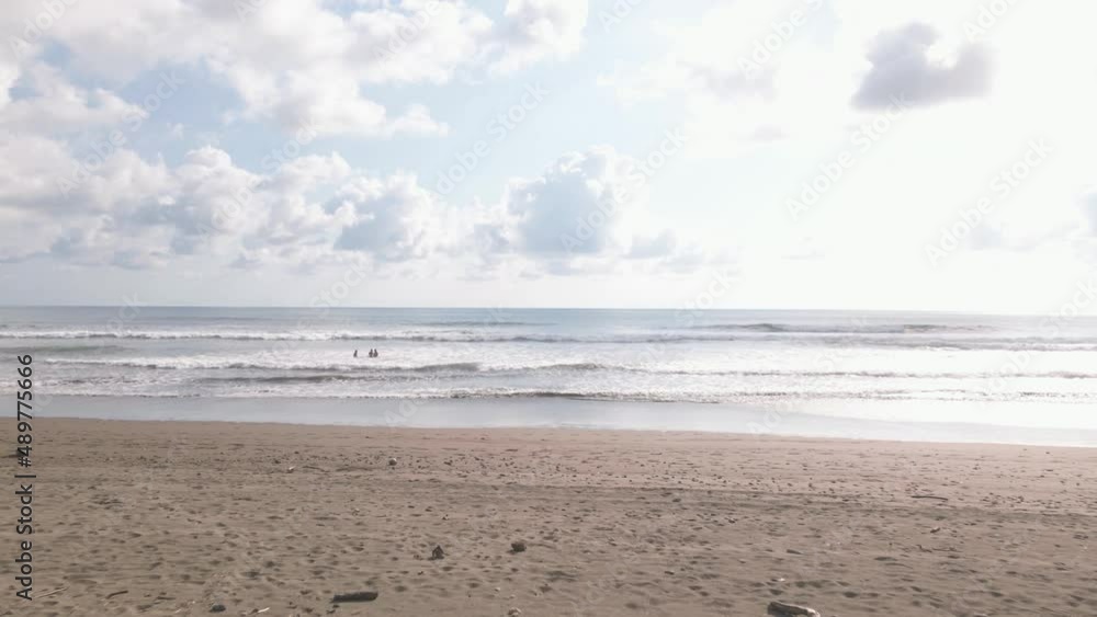 Aerial View of three people in the Dominical Beach In Costa Rica, Tracking Shot Wide.