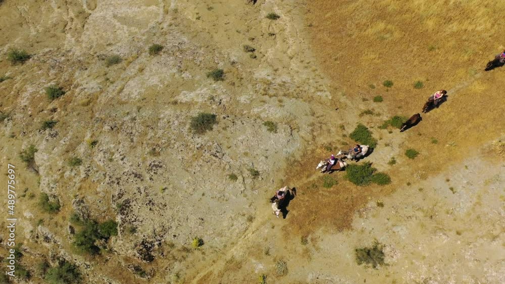 Aerial view around people horseback riding over the highlands of Armenia - high angle, circling, drone shot Aerial view around people horseback riding over the highlands of Armenia - high angle, circling, drone shot