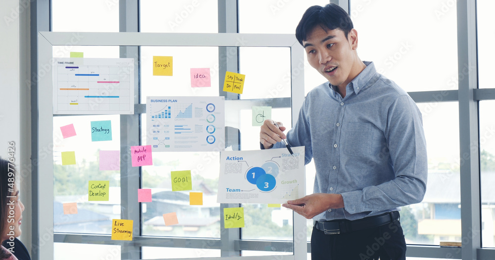 Fototapeta premium Happy business people meeting present graph chart investment, business data in meeting room. Group of business people meeting in conference room. Asian businessman speech, present teamwork partnership