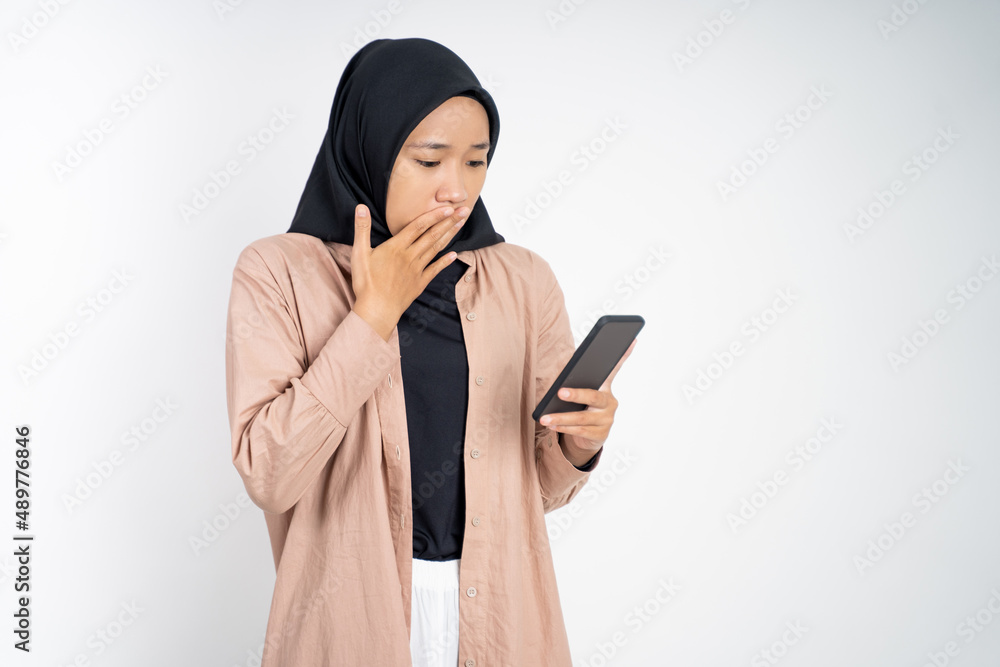 shocked muslim woman in hijab using a cell phone shocked muslim woman in hijab using a cell phone