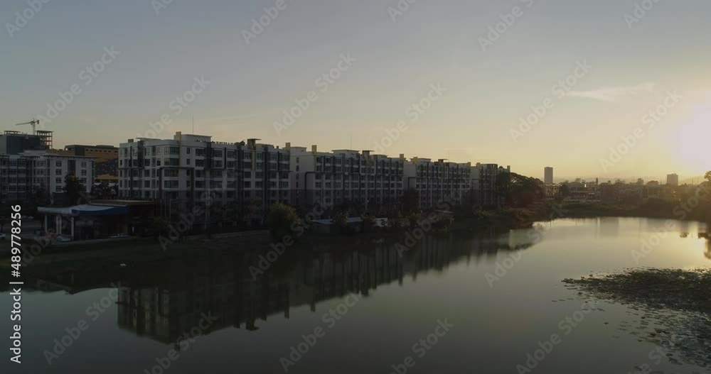 Apartment building complex next to small lake during golden hour sunset, Chiangmai Apartment building complex next to small lake during golden hour sunset, Chiangmai