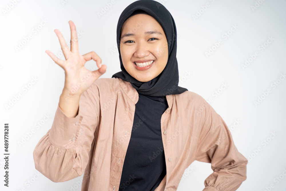 Asian woman in hijab smiling with okay gesture Asian woman in hijab smiling with okay gesture