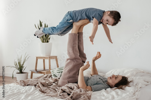 


119 / 10000

mom plays with her son at home. happy mom and son perform the airplane exercise. on the bed in a cozy sunny room. photo