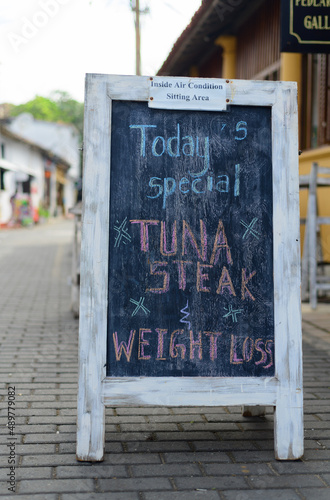 Slika na platnu White wooden framed chalkboard, handwritten today's special menu, display on outdoor street pavement