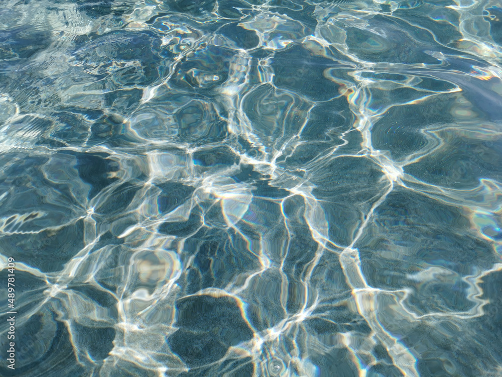 Obraz premium Crystal clear blue water of the Mediterranean Sea on the beach of Fig Tree Bay, white sand is visible at the bottom. Water background.