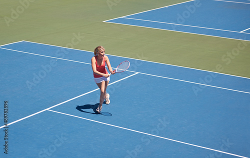 Winning the game. Woman playing tennis on the tennis court. © Marine G/peopleimages.com