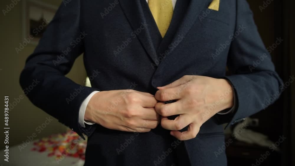 Close view of the luxury watches on the hand of a handsome businessman in a tuxedo and in a shirt with cufflinks. businessman dressed costume before meeting with partners Close view of the luxury watches on the hand of a handsome businessman in a tuxedo and in a shirt with cufflinks. businessman dressed costume before meeting with partners