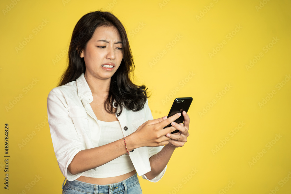 woman feel disgusted and shocked while looking at her mobile phone woman feel disgusted and shocked while looking at her mobile phone