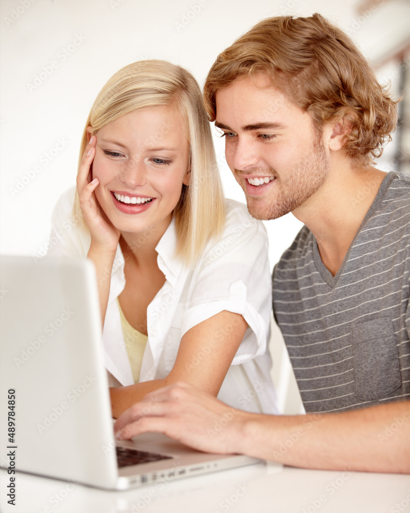 Reading his latest blog. A young couple using a laptop to surf the net. Reading his latest blog. A young couple using a laptop to surf the net.