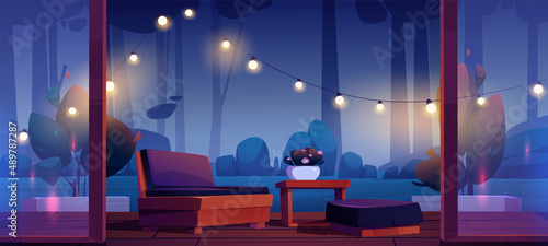 House terrace with table, couch, string lights and view to dark garden at night. Vector cartoon illustration of wooden veranda with glass walls and forest or park landscape with trees at evening