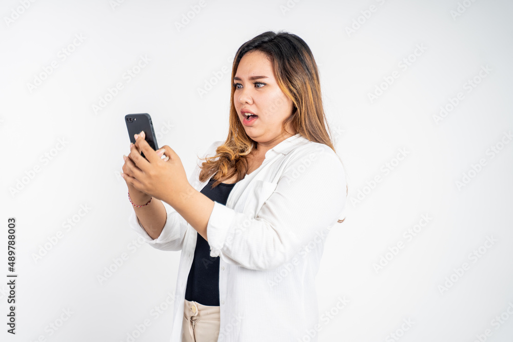 woman feel disgusted and shocked while looking at her mobile phone woman feel disgusted and shocked while looking at her mobile phone