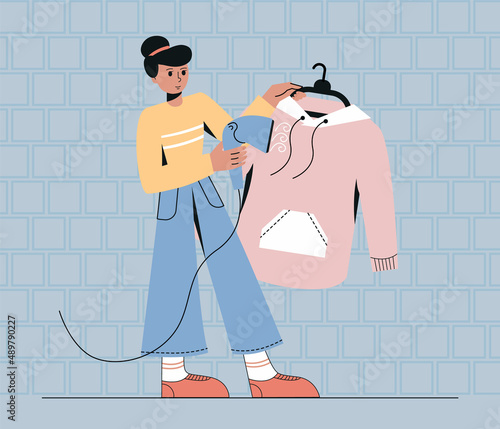 Woman use steamer iron for clothing.