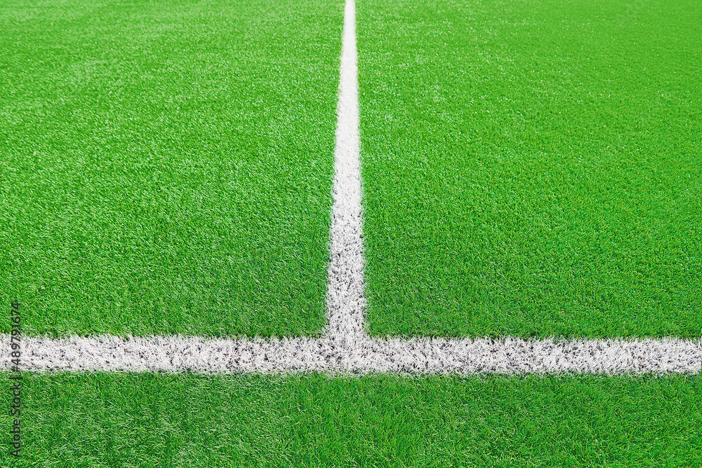 Obraz premium Part of football or soccer field close up, Artifical green grass with white border lines, Astroturf at stadium for spart games
