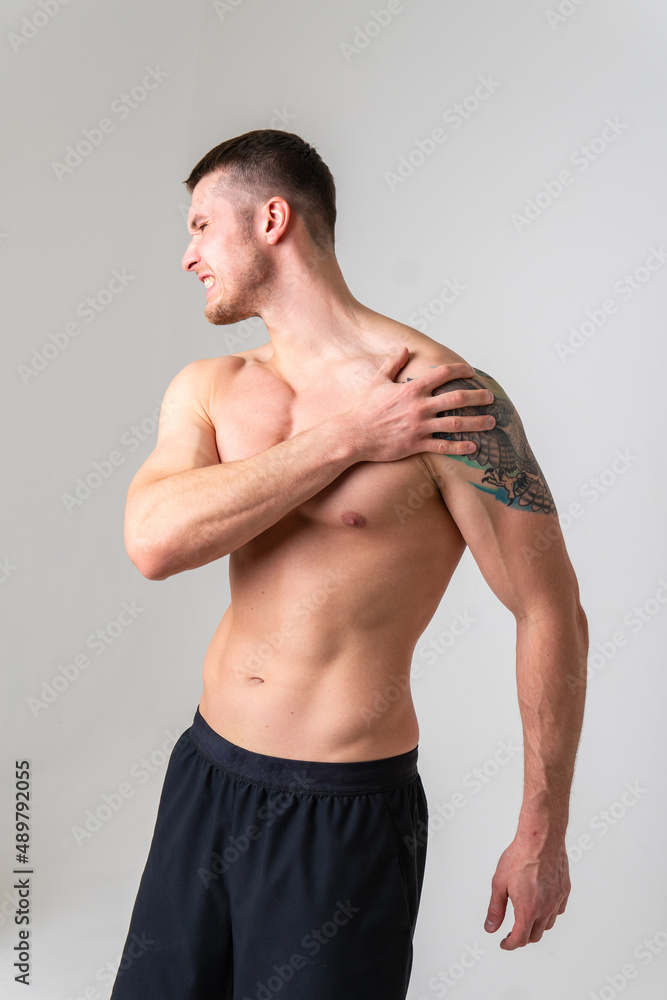 A sore shoulder joint muscle in a white man on a white background pain body injury, cramp man health stress, human holding. lumbar sickness, back suffer attractive