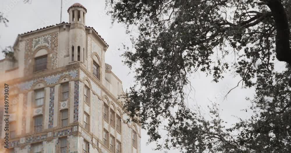 A large Spanish-style building with a memorial flame burning in the foreground in Laredo, Texas