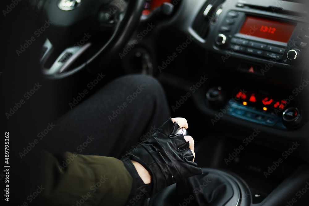 Fototapeta premium Hand on the car gear knob. The driver switches the speed in the car. Hand on gear lever.