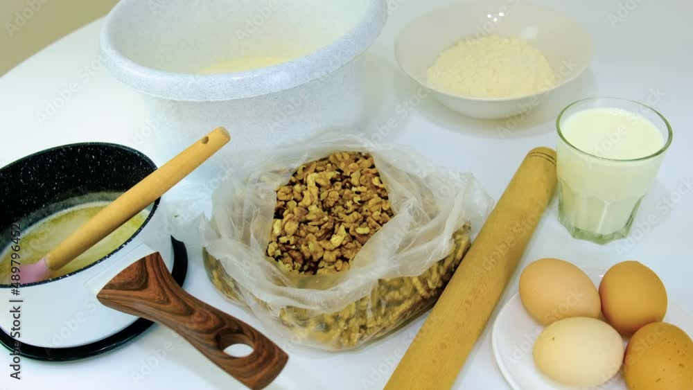 A woman is kneading dough in the kitchen. Selective focus. A woman is kneading dough in the kitchen. Selective focus.