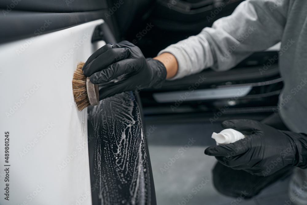 Worker using automotive soap and brush for carwash Worker using automotive soap and brush for carwash