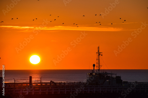 Boat at river Yser estuary, North sea at sunset on a crisp winter day, 27 February 2022. photo