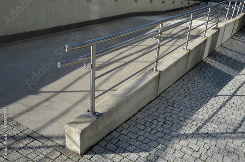 railing with two handrails. made of galvanized steel prisms. the lower railing is a protection against wheelchairs. ramp for the immobile in the housing estate, stainless steel, staircase, ramp